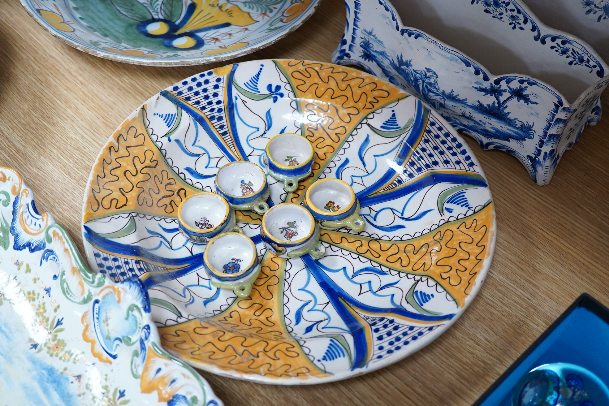 Two 18th century Delft polychrome chargers, five other faience chargers, a rectangular 19th century French faience dish and a blue and white letter rack
